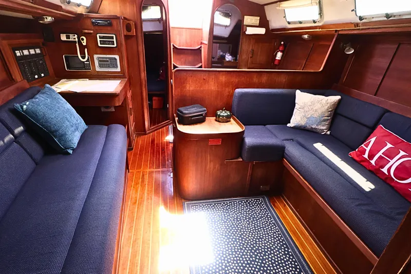 Slide: The Image of 1989 J Boat J 40 interior with wooden finish, blue seating, and nautical decor. - 21