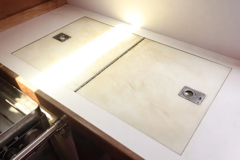 Slide: The Image of 1989 J Boat J 40 galley countertop with storage compartments and metal handles. - 25
