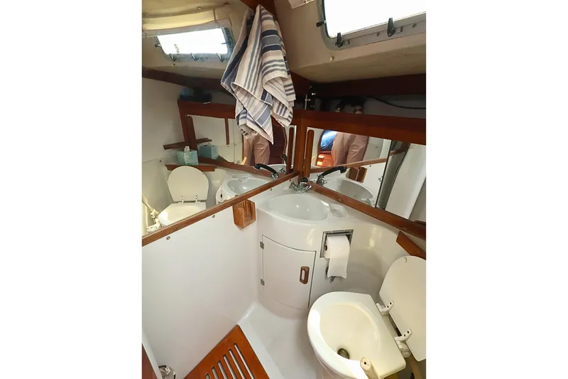 Slide: The Image of Compact bathroom in 1989 J Boat J 40, featuring sink, toilet, and mirrors. - 35