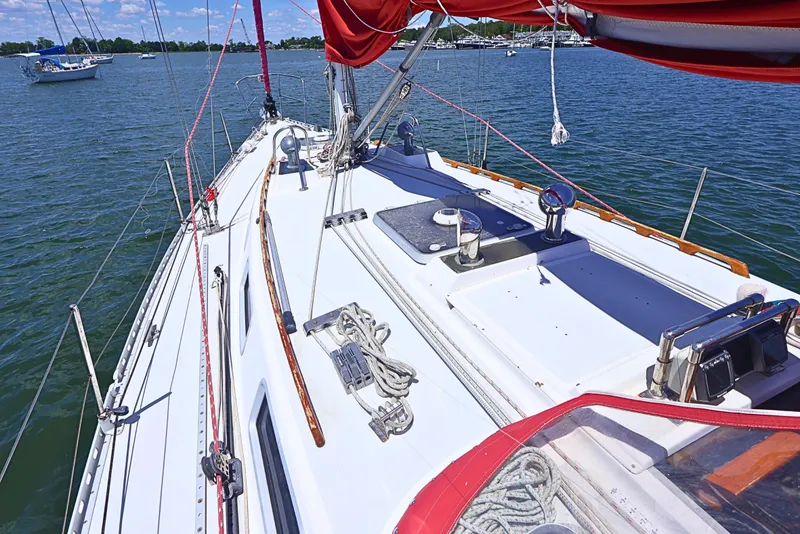 Slide: The Image of 1989 J Boat J 40 sailboat deck with red sails on calm water. - 4