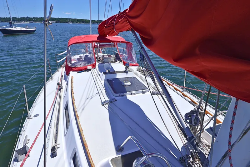 Slide: The Image of 1989 J Boat J 40 sailboat with red canopy on calm water. - 5