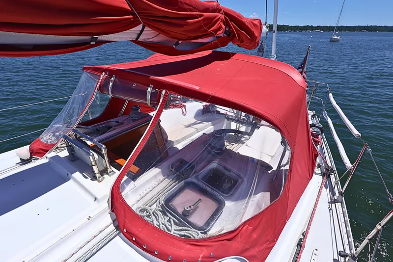 Slide: The Image of 1989 J Boat J 40 sailboat with red canopy on calm water. - 6