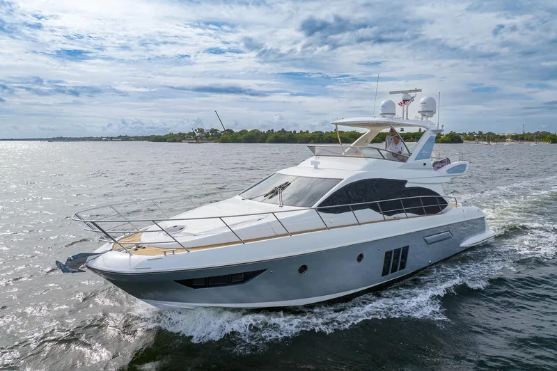 Slide: The Image of 2014 Azimut 54 Flybridge yacht cruising on open water under a cloudy sky. - 2