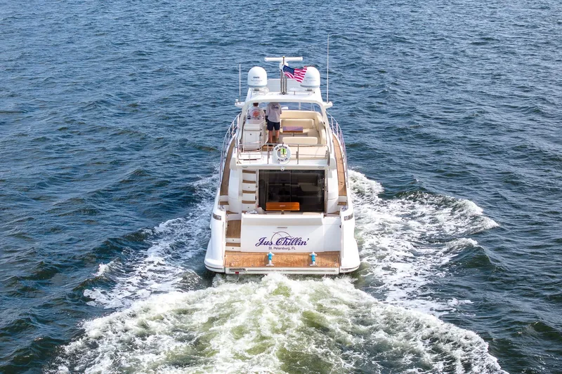 Slide: The Image of 2014 Azimut 54 Flybridge yacht cruising on open water, rear view. - 5