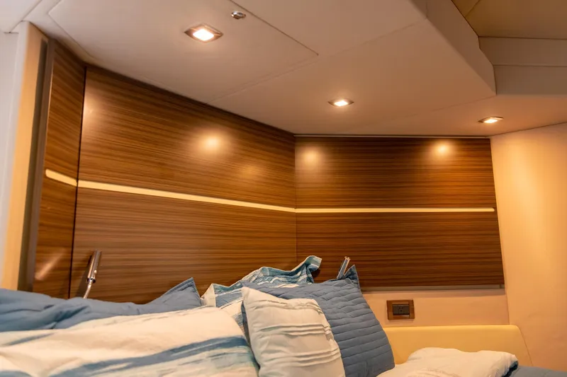 Slide: The Image of Luxurious interior of 2014 Azimut 54 Flybridge yacht with wood paneling and cozy bedding. - 57