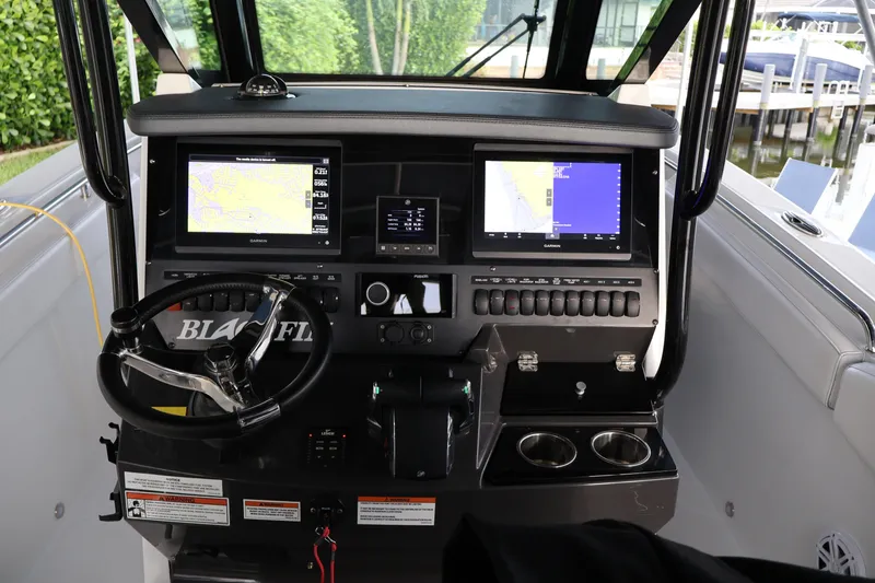 Slide: The Image of 2021 Blackfin 272 CC boat dashboard with dual Garmin displays and steering wheel. - 11