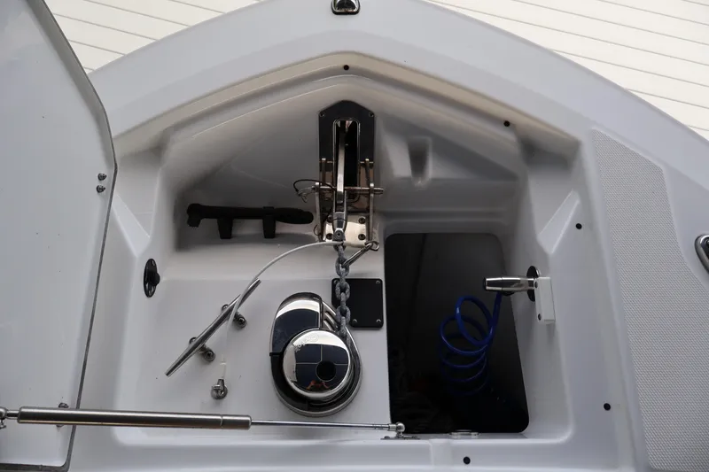 Slide: The Image of 2021 Blackfin 272 CC boat anchor compartment with stainless steel fittings and coiled blue hose. - 23
