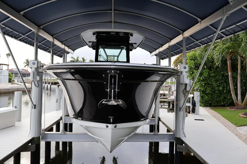 Slide: The Image of 2021 Blackfin 272 CC boat docked under a canopy, showcasing sleek design and modern features. - 3