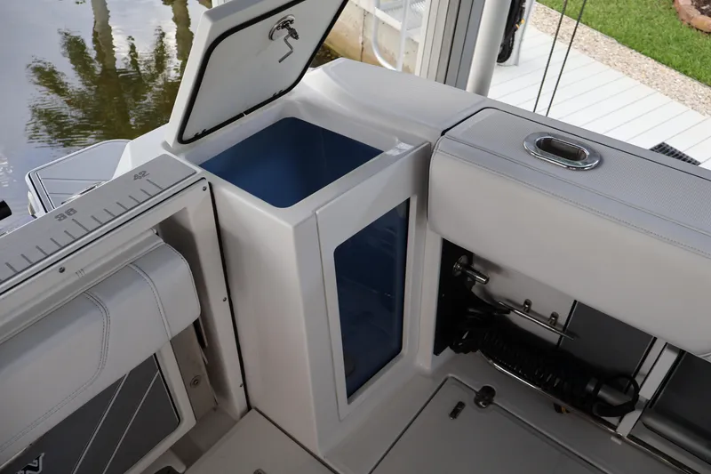 Slide: The Image of 2021 Blackfin 272 CC boat interior with open storage compartment and fishing rod holder. - 35