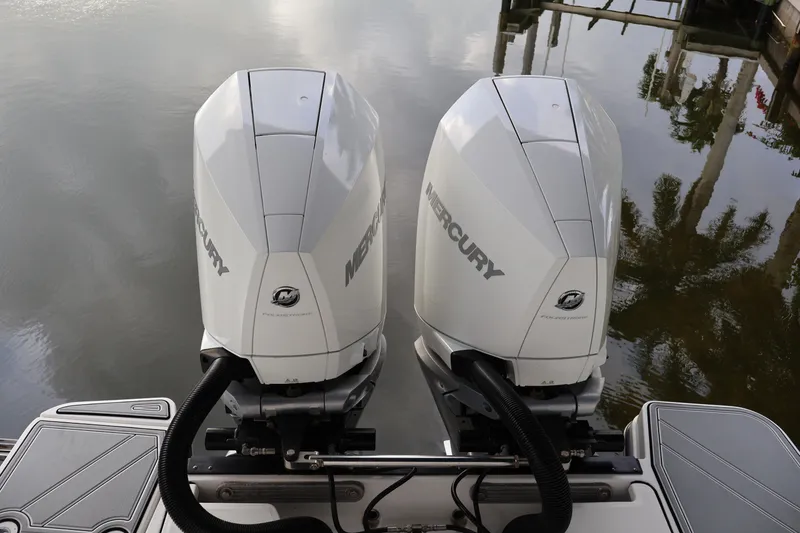 Slide: The Image of Twin Mercury outboard engines on a 2021 Blackfin 272 CC boat, docked by calm water. - 5