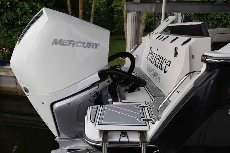 Slide: The Image of 2021 Blackfin 272 CC boat with Mercury engine, docked in a lush setting. - 9