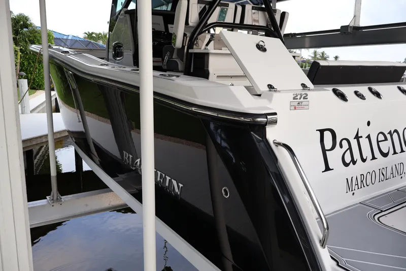Slide: The Image of 2021 Blackfin 272 CC boat docked, featuring sleek design and "Patience" name on the side. - 42