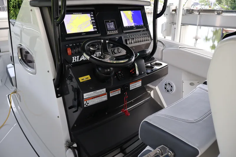 Slide: The Image of 2021 Blackfin 272 CC boat cockpit with advanced navigation displays and steering wheel. - 7