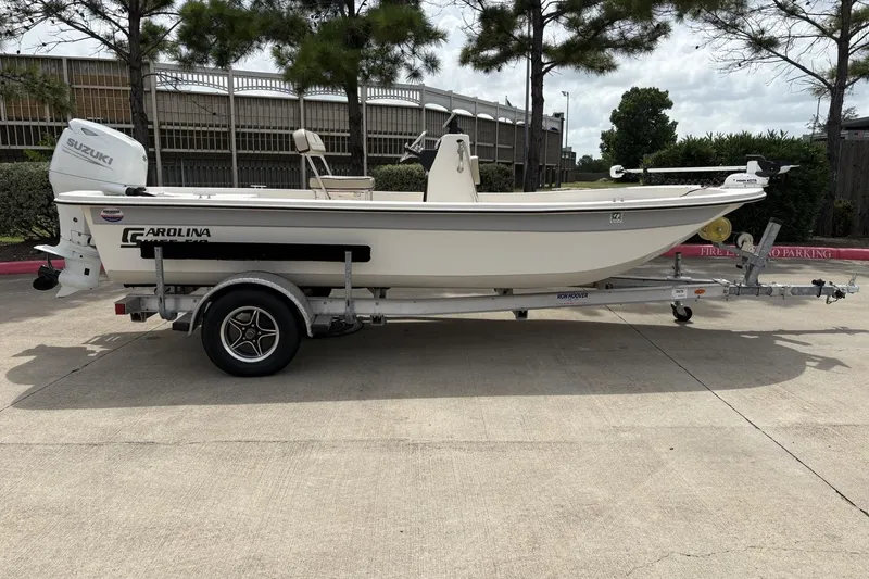The Image of 2024 Carolina Skiff E18 JVX CC boat on trailer, parked outdoors. - 0