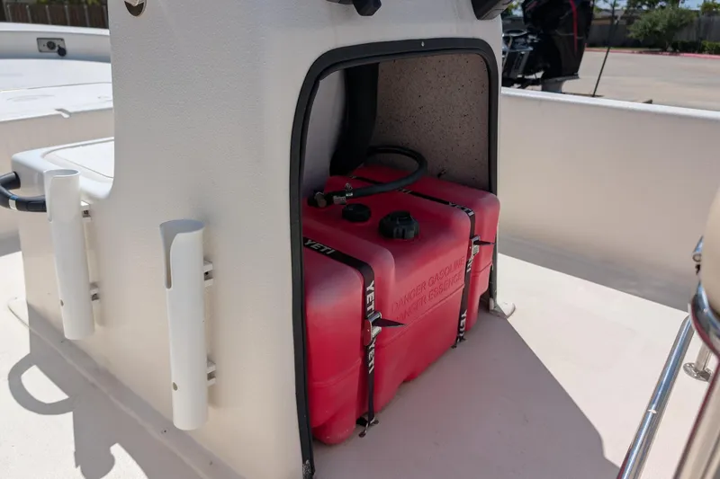 Slide: The Image of 2024 Carolina Skiff E18 JVX CC boat with red fuel tank storage compartment. - 11