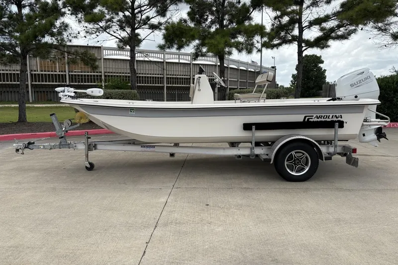 Slide: The Image of 2024 Carolina Skiff E18 JVX CC boat on trailer, parked outdoors. - 6