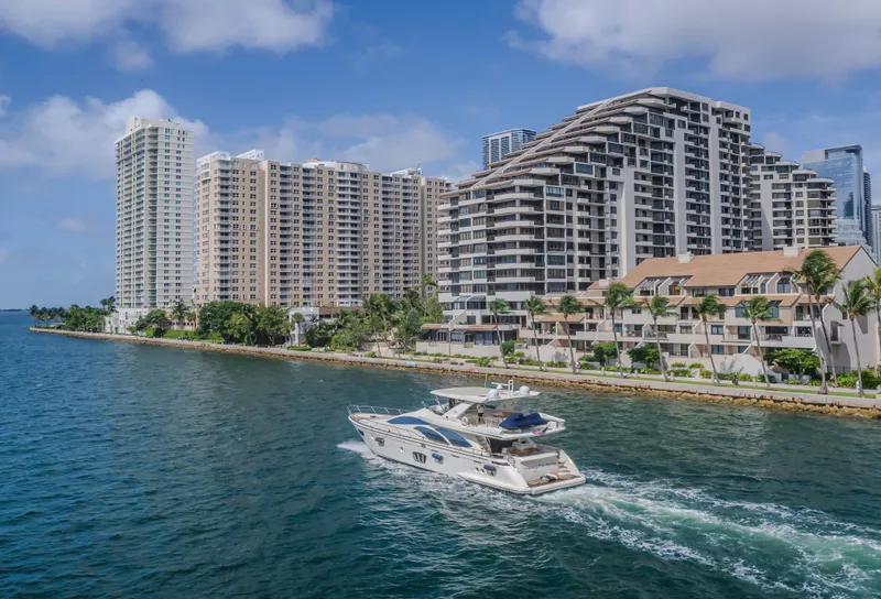 Slide: The Image of Azimut Flybridge 2008 yacht cruising near waterfront high-rise buildings under a clear blue sky. - 34