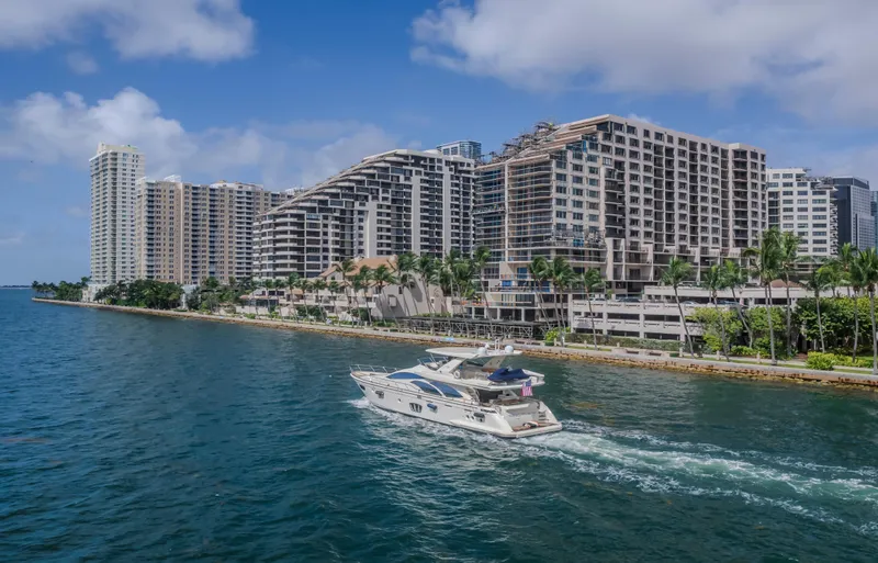 Slide: The Image of 2008 Azimut Flybridge yacht cruising near waterfront cityscape with modern high-rise buildings. - 35