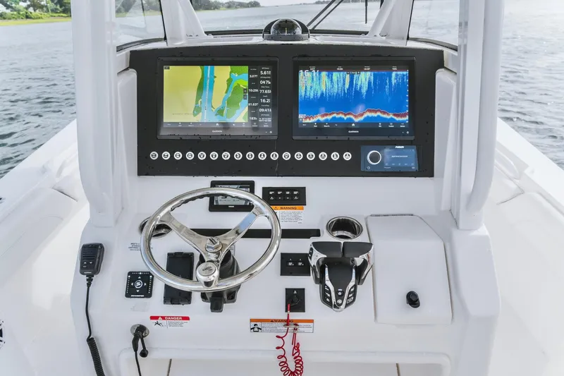 Slide: The Image of 2025 Regulator 28 boat dashboard with dual navigation screens and steering wheel. - 10