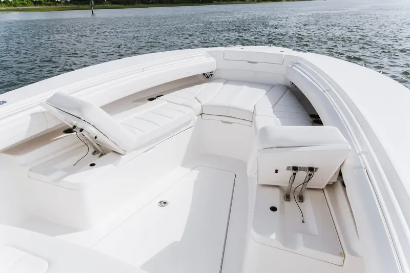 Slide: The Image of 2025 Regulator 28 boat interior with white cushioned seating on calm water. - 12