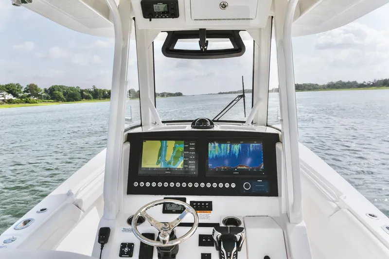 Slide: The Image of 2025 Regulator 28 boat cockpit with advanced navigation displays on a serene waterway. - 18