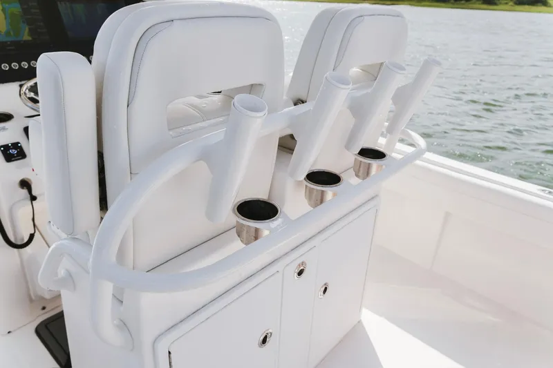 Slide: The Image of 2025 Regulator 28 boat interior with rod holders and cup holders on a white seat. - 19