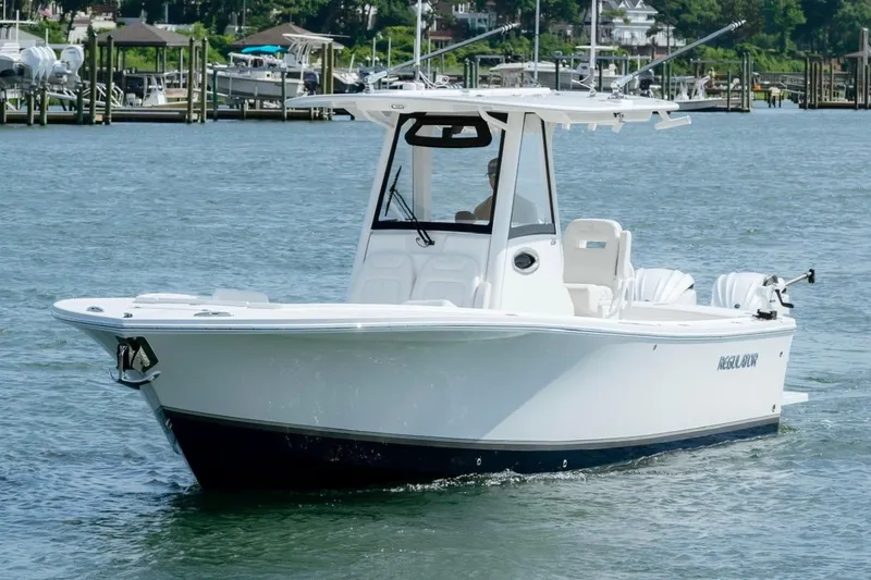 Slide: The Image of 2025 Regulator 28 boat cruising on a sunny day in a marina setting. - 3