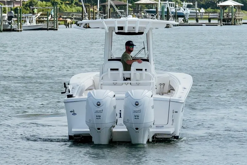 Slide: The Image of 2025 Regulator 28 boat with dual Yamaha engines navigating a marina. - 8