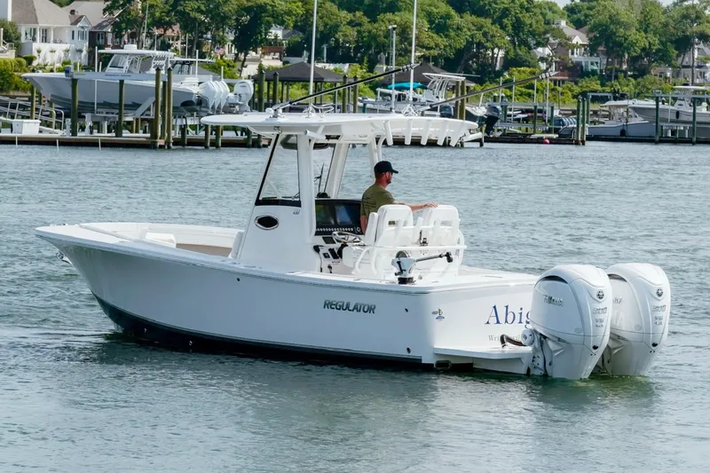 Slide: The Image of 2025 Regulator 28 boat with dual engines cruising in a marina. - 9