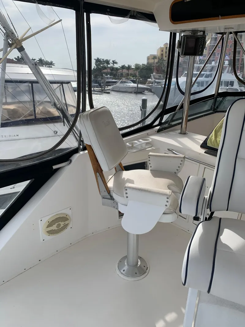 Slide: The Image of Captain's chair on the 1985 Ocean Yachts 55 Super Sport, docked at a marina. - 7