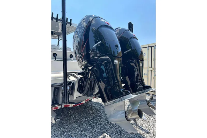 Slide: The Image of Twin Mercury outboard engines on a 2020 Blackwood 270 LXF boat, parked on gravel. - 12