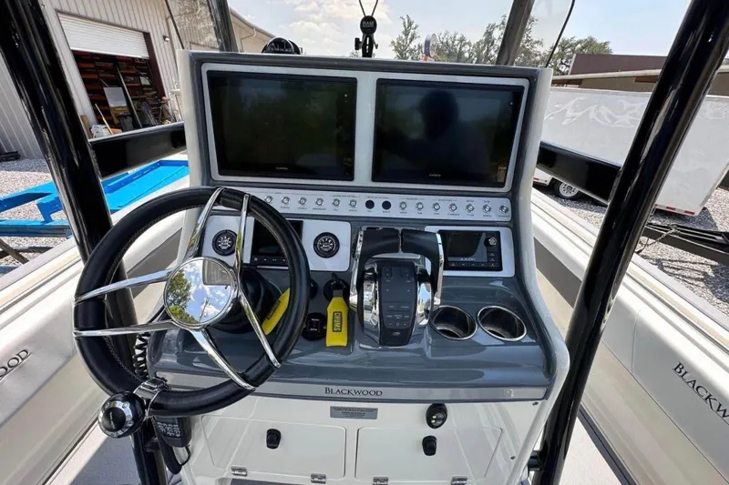 Slide: The Image of 2020 Blackwood 270 LXF boat dashboard with steering wheel and dual screens. - 17