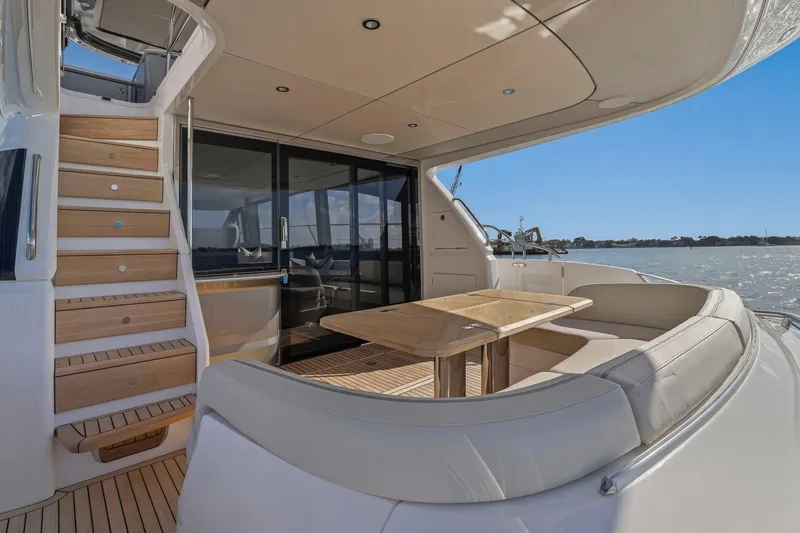 Slide: The Image of Luxurious 2026 Princess F65 yacht deck with elegant seating and wooden staircase. - 23
