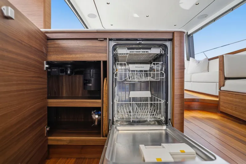 Slide: The Image of Luxury yacht kitchen with open Miele dishwasher, wood cabinetry, and modern design, Princess F65 2026. - 40