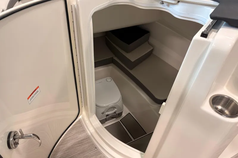 Slide: The Image of Interior view of 2026 Sea Ray SDX 230 boat cabin with compact toilet. - 12
