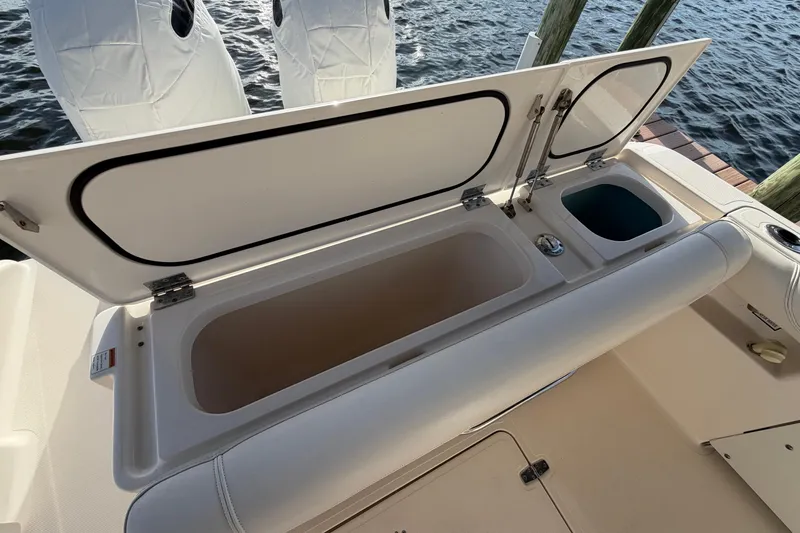 Slide: The Image of 2014 Pursuit DC 265 Dual Console boat with open storage compartment and seating. - 13