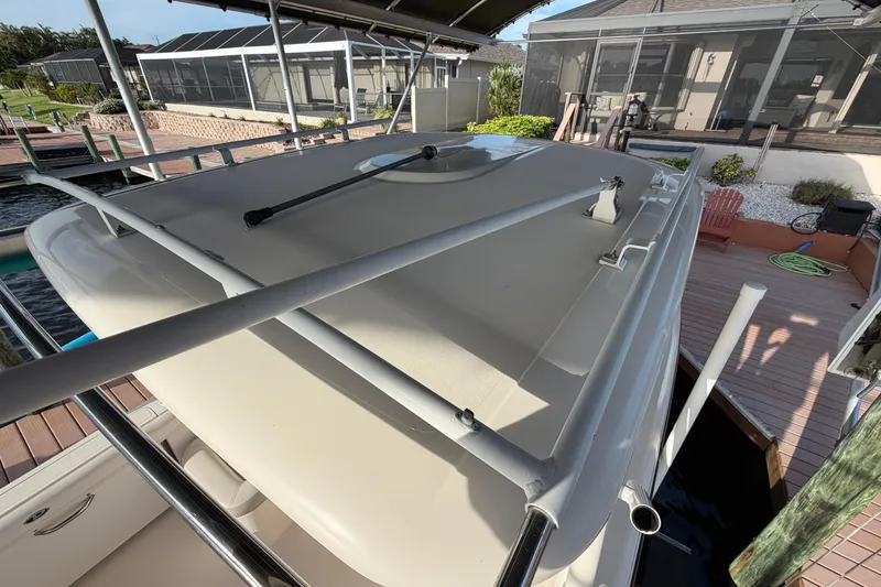 Slide: The Image of 2014 Pursuit DC 265 Dual Console boat docked under a canopy. - 15