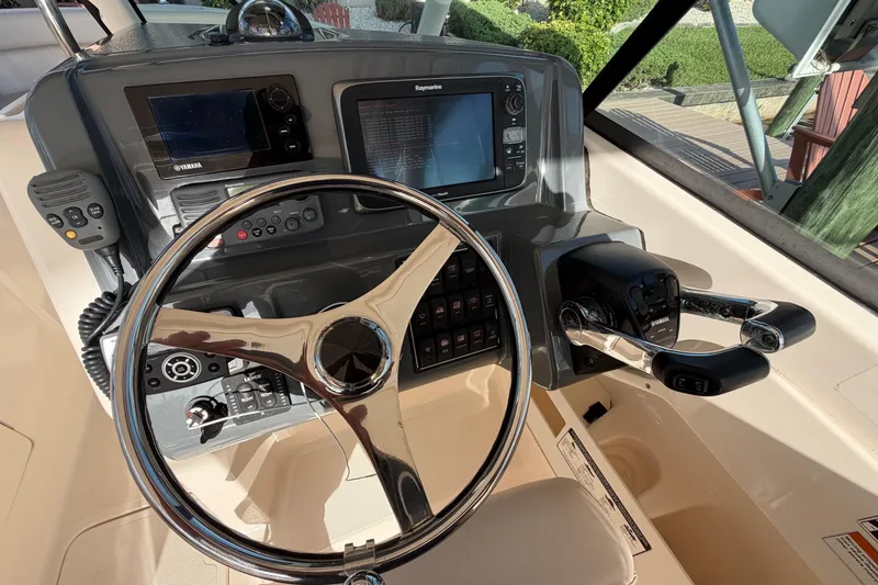 Slide: The Image of Steering console of a 2014 Pursuit DC 265 Dual Console boat with navigation equipment. - 21