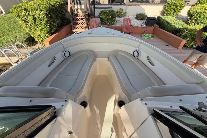 Slide: The Image of 2014 Pursuit DC 265 Dual Console boat interior with cushioned seating and speakers. - 22