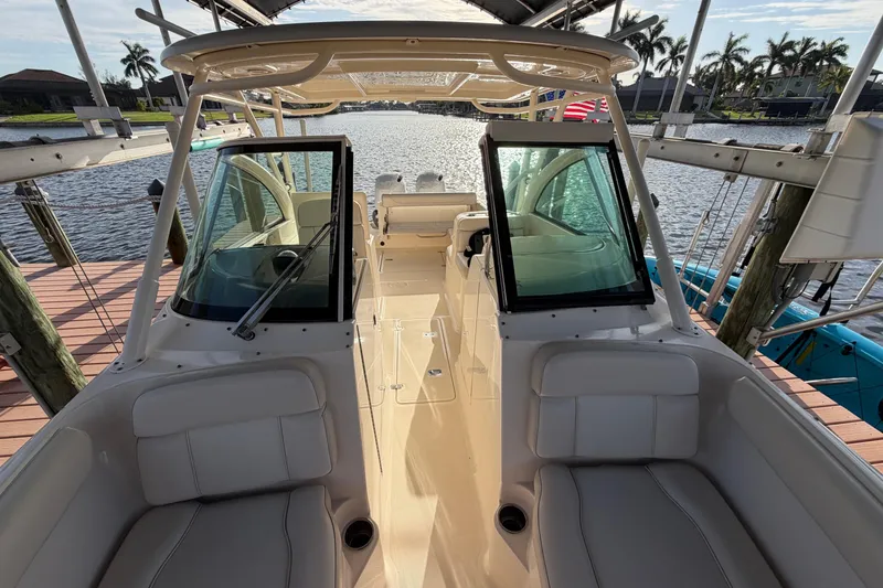Slide: The Image of 2014 Pursuit DC 265 Dual Console boat docked by a scenic waterfront. - 23