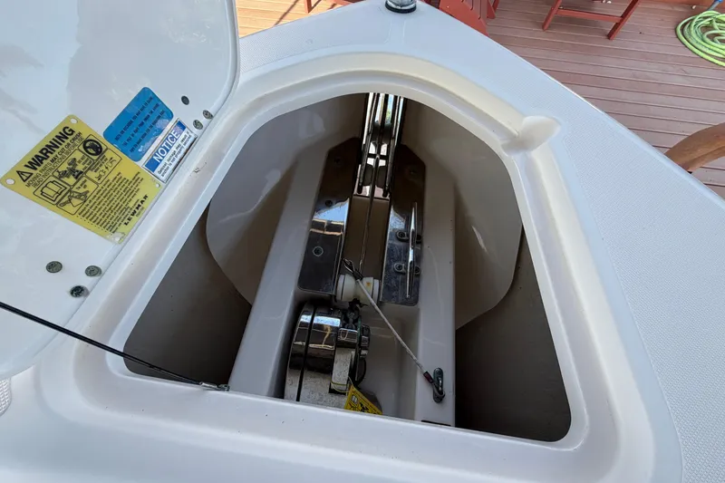 Slide: The Image of Anchor compartment of 2014 Pursuit DC 265 Dual Console boat, featuring safety labels. - 25