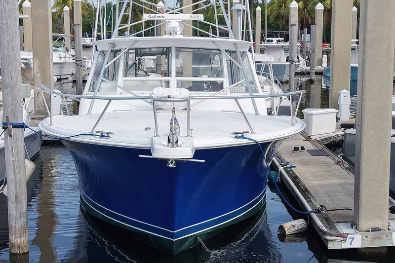 Slide: The Image of 2008 Luhrs 41 Open boat docked, featuring a sleek blue hull and spacious deck. - 101
