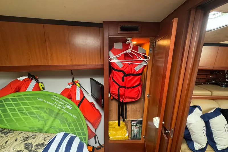 Slide: The Image of 2008 Luhrs 41 Open cabin with life jackets, storage, and wooden cabinetry. - 69