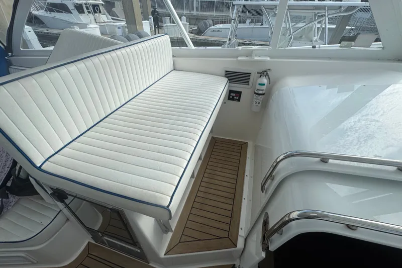 Slide: The Image of 2008 Luhrs 41 Open boat interior with white cushioned seating and wooden flooring. - 40