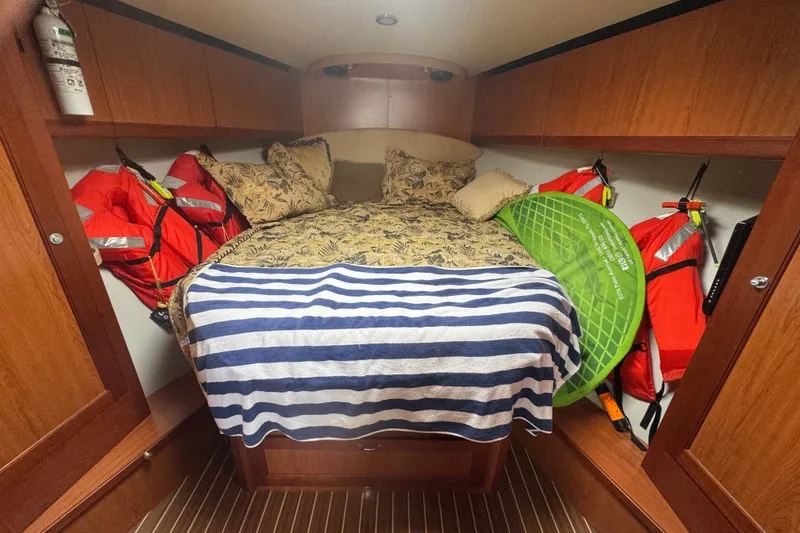 Slide: The Image of Cozy cabin interior of 2008 Luhrs 41 Open with bed, life jackets, and striped blanket. - 71