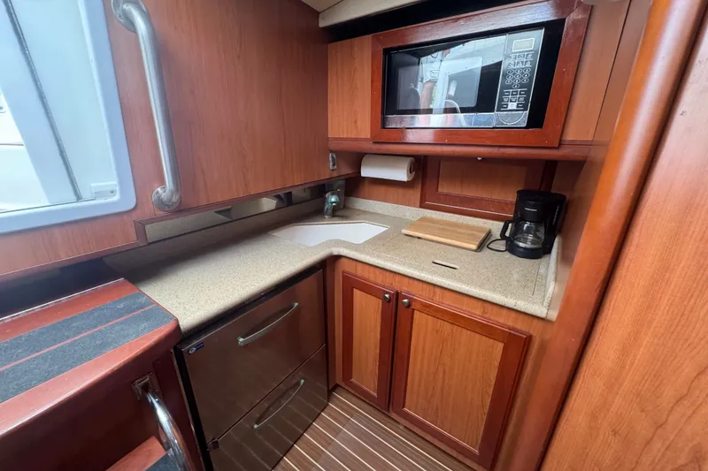 Slide: The Image of 2008 Luhrs 41 Open yacht kitchen with wood cabinetry, microwave, and countertop appliances. - 93