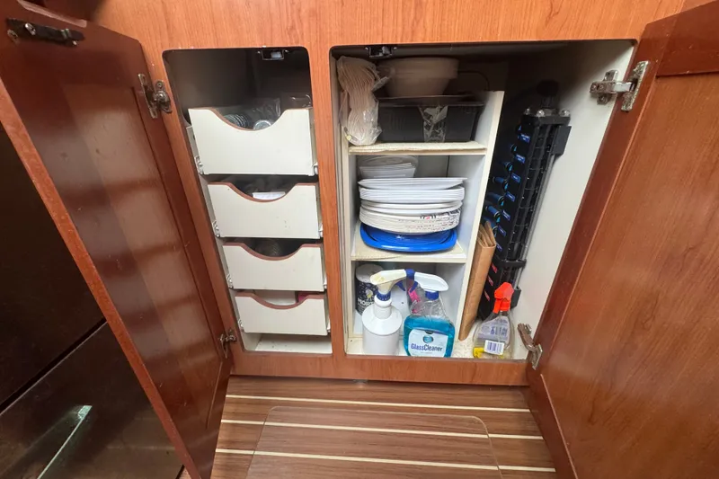 Slide: The Image of Cabinet storage on 2008 Luhrs 41 Open boat, featuring cleaning supplies and kitchenware. - 86