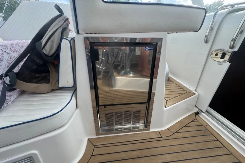 Slide: The Image of 2008 Luhrs 41 Open boat interior with seating, backpack, and stainless steel fridge. - 59