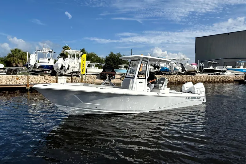 Slide: The Image of 2026 Blazer Bay Makaira 2800 boat on water, docked near marina with clear sky. - 9