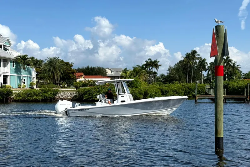 Slide: The Image of 2026 Blazer Bay Makaira 2800 cruising on a sunny waterway near palm trees and houses. - 13